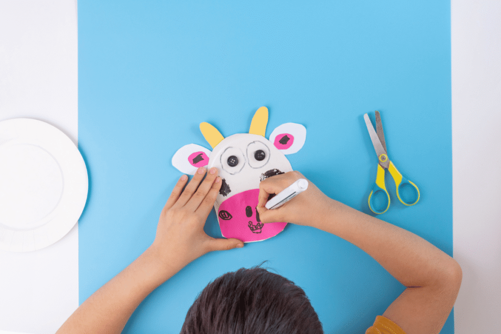 child making paper plate animal craft as one of the easy DIY crafts for kids at home