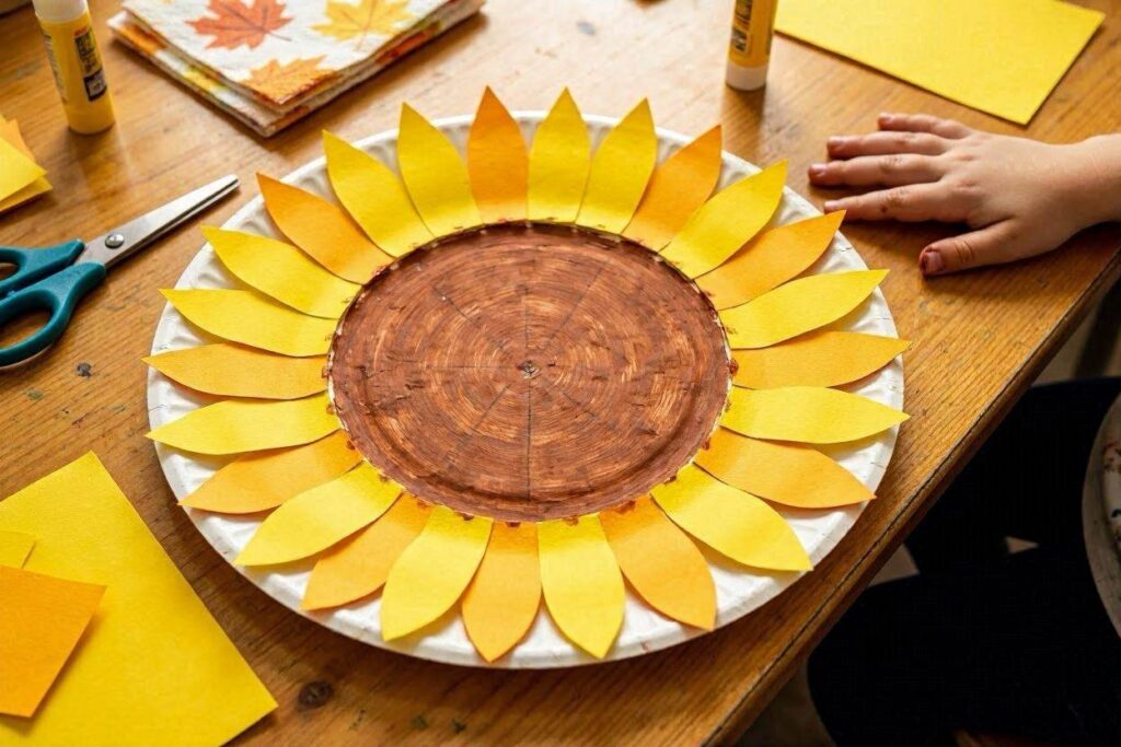 Paper plate sunflower fall craft with yellow petal 